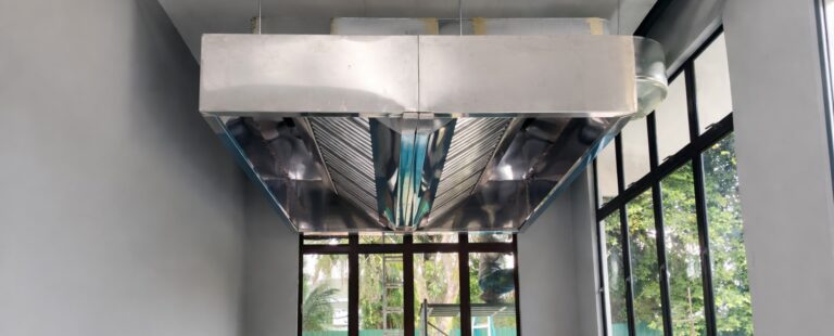 Island-style commercial kitchen exhaust hood system installed in Malaysia with stainless steel canopy and ducting