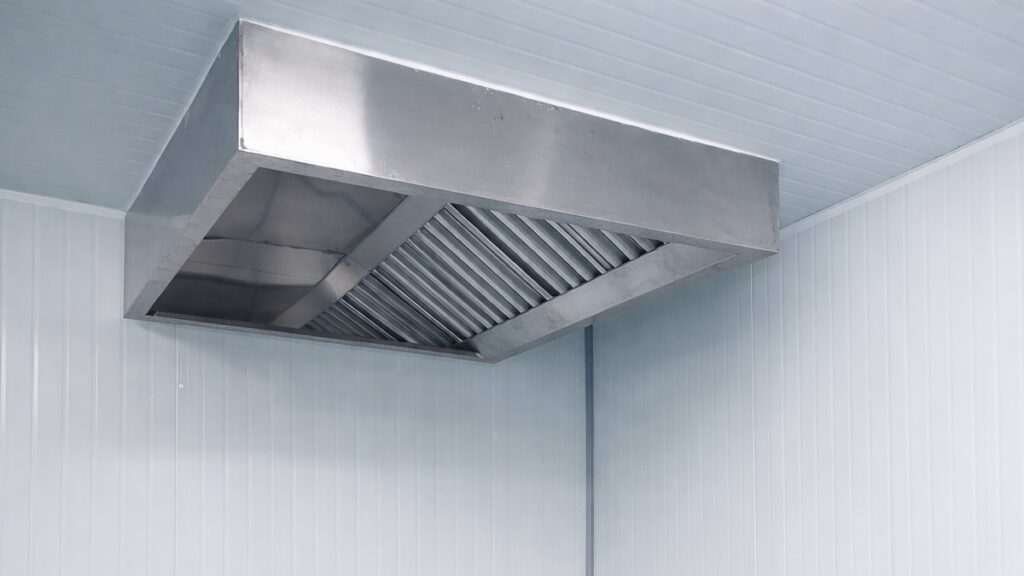 Wall-mounted stainless steel kitchen exhaust hood installed in commercial kitchen in Malaysia