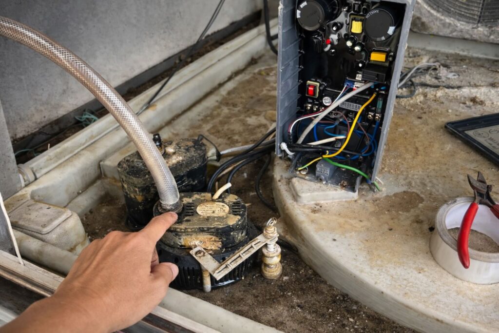 technician inspecting water pump and PC Board inside industrial evaporative air cooler during maintenance