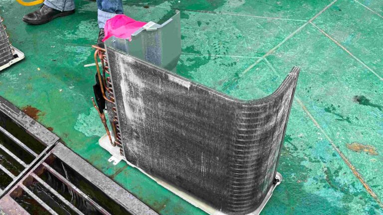 dirty air conditioner condenser coil being cleaned with chemical solution during servicing in Malaysia