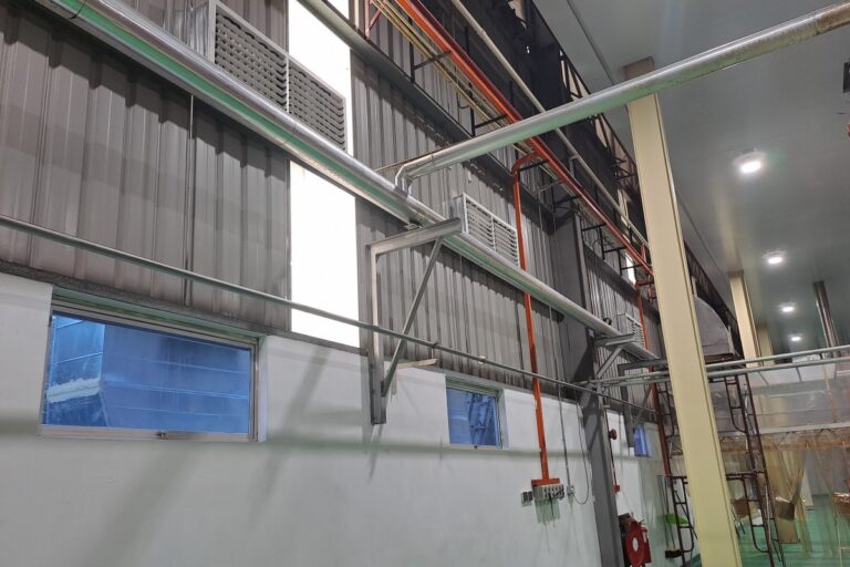 Ducting and air outlets installed for evaporative air cooler supply inside an instant noodle factory production floor.