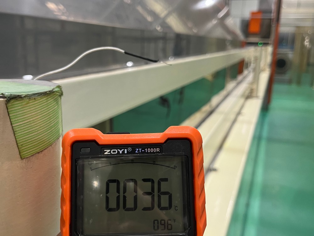 Temperature meter showing 36°C after evaporative air cooler installation at an instant noodle factory production floor.