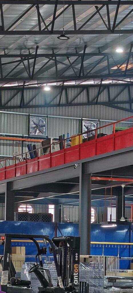 Box type exhaust fans installed on the zinc wall of a metal fabrication factory for ground and mezzanine floor air extraction.