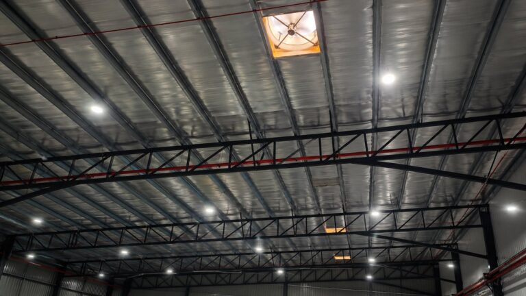 Interior view of rooftop exhaust fan openings installed above a metal fabrication factory for high-level hot air extraction.