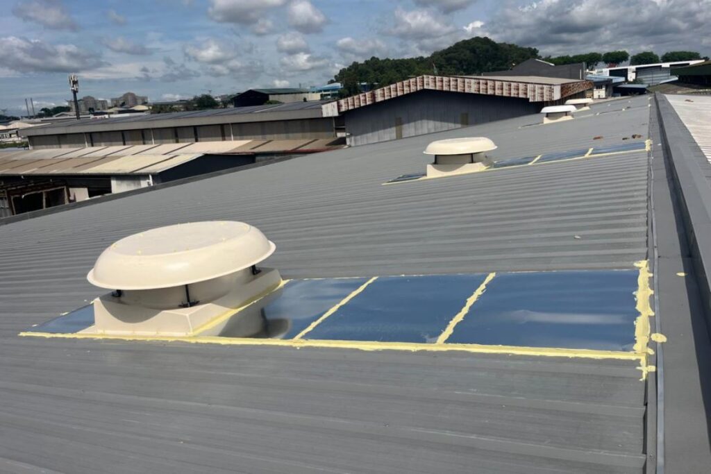 Rooftop exhaust fans installed on a metal fabrication factory roof for high-level hot air extraction.