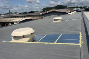 Rooftop exhaust fans installed on a metal fabrication factory roof for high-level hot air extraction.