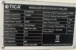 Air-cooled chiller nameplate showing 130 kW cooling capacity and 22.4 m³/h rated water flow.