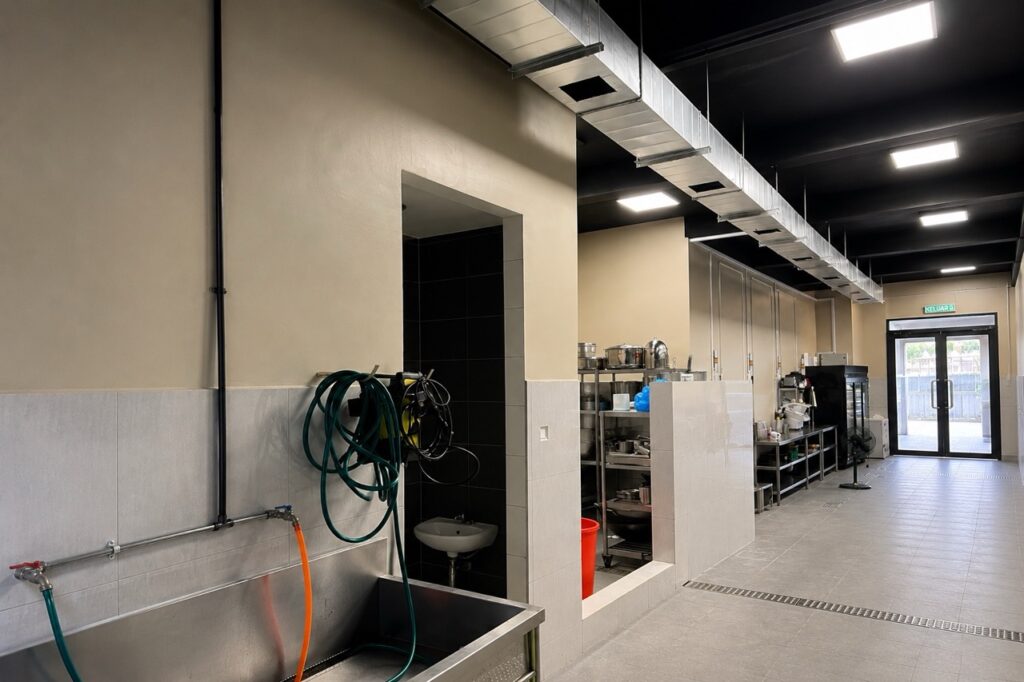 High-level air cooler ducting and discharge openings installed above the occupied working area.