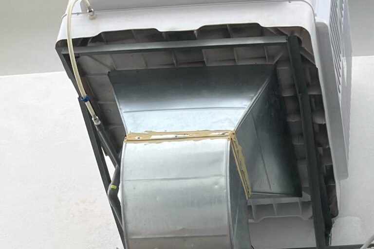Industrial evaporative air cooler resting on a support frame without visible positive mechanical restraint.