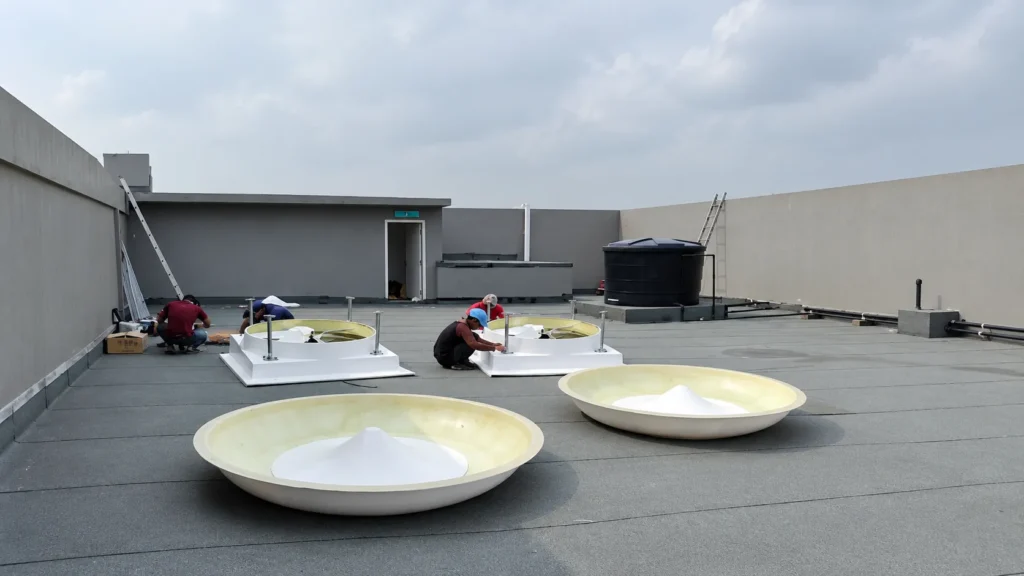 CrystalAir EXR-450 rooftop exhaust fans being installed on an industrial factory roof.