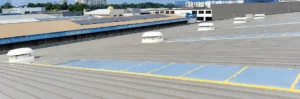Powered rooftop exhaust fans installed on a factory roof for mechanical hot air extraction.