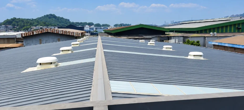 Rooftop exhaust fans installed on neighbouring industrial factories for mechanical ventilation.